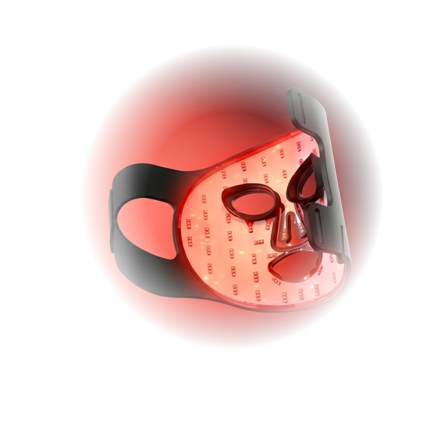 Lumira LED light therapy face mask, glowing red, resting on a soft draped surface